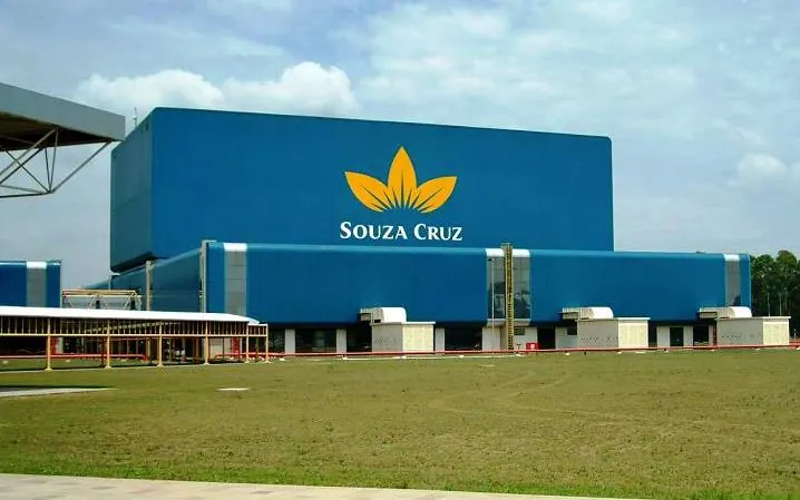 Fábrica da Souza Cruz com o logo da empresa na fachada azul.